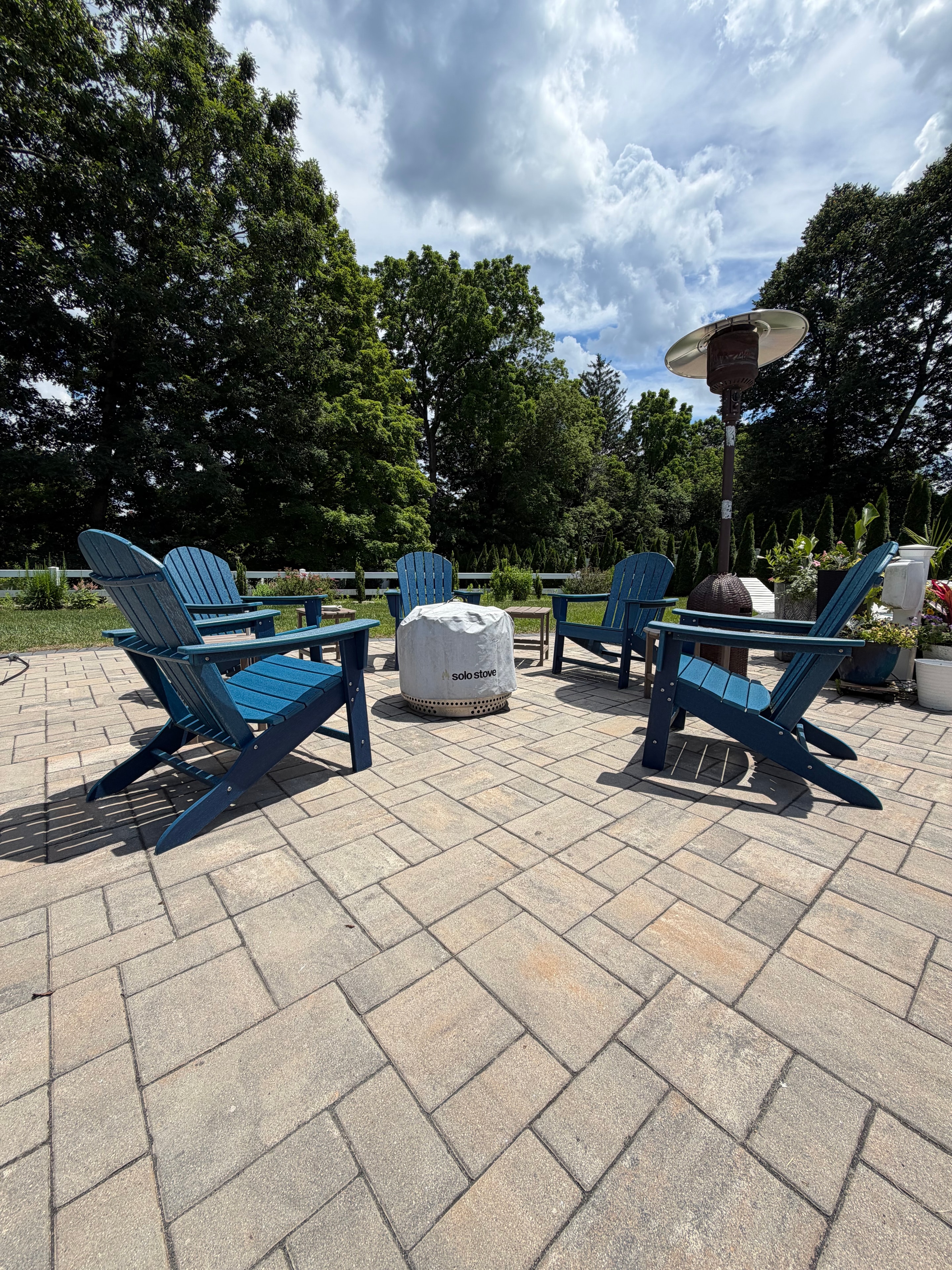 The JenMore Estate patio — Solo Stove fire pit surrounded by blue Adirondack chairs
